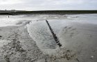 Buhne K ragt hoch aus dem Sand, im Hintergrund links oben die neue Strandmauer